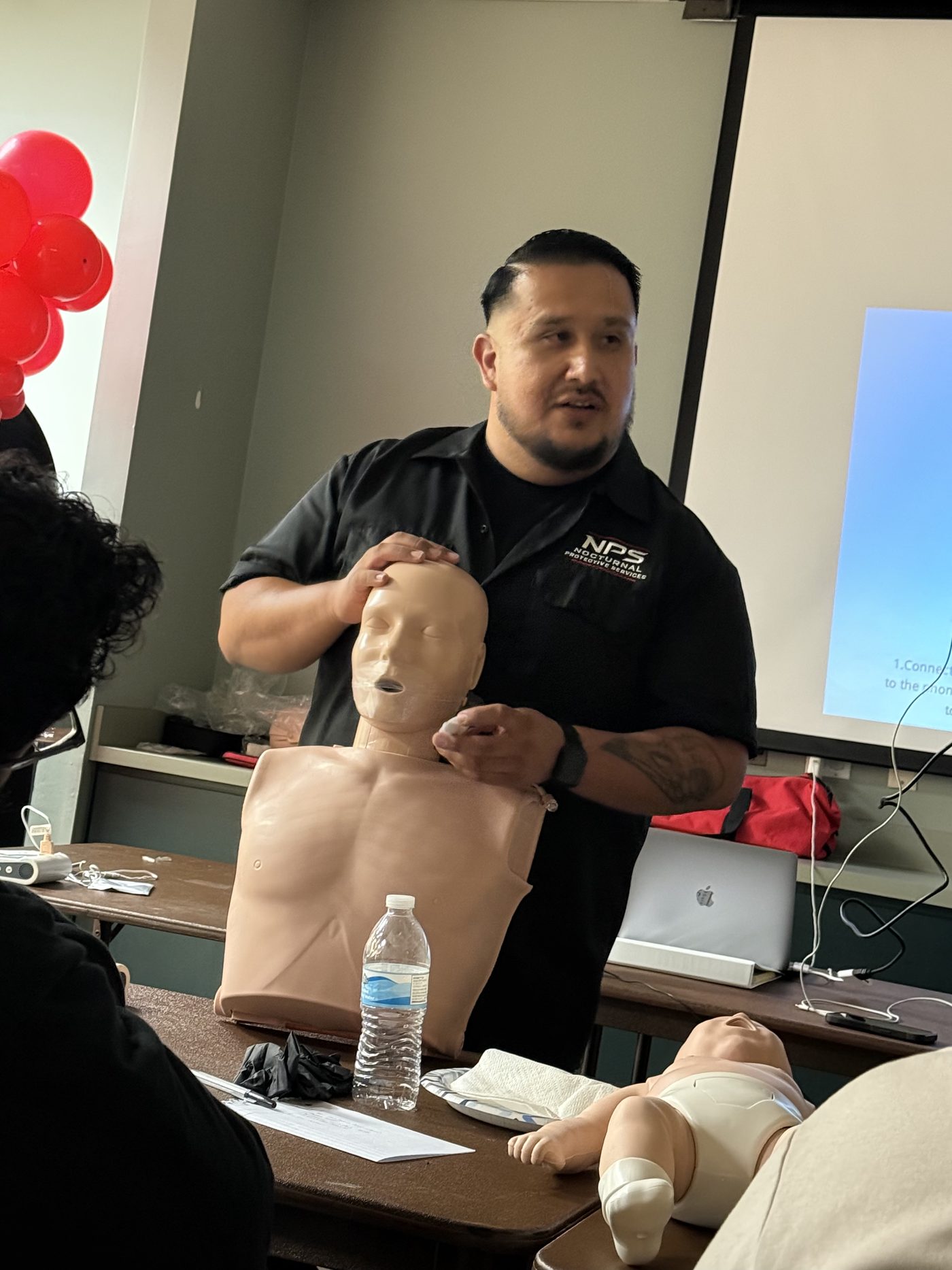 NPS instructor Mario Galvan demonstrating CPR on a training mannequin